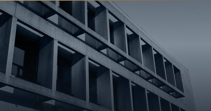 Betonfassade mit tiefem, regelmäßigem Fensterraster.