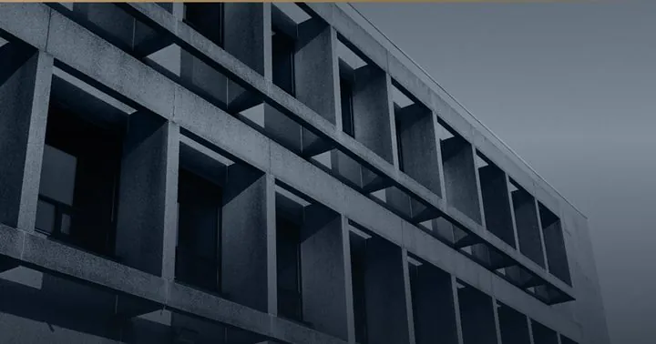 Betonfassade mit tiefem, regelmäßigem Fensterraster.