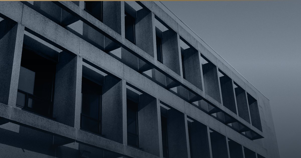 Betonfassade mit tiefem, regelmäßigem Fensterraster.