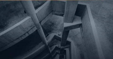 Ineinandergreifende Betonebenen eines Treppenhauses.