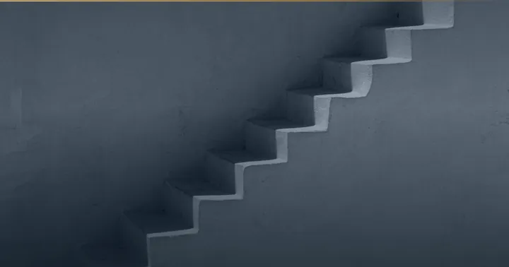 Treppe, die an einer glatten Wand aufsteigt.