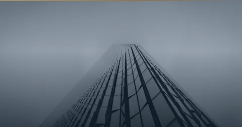 Hochhaus, das sich nach oben im Nebel verliert.